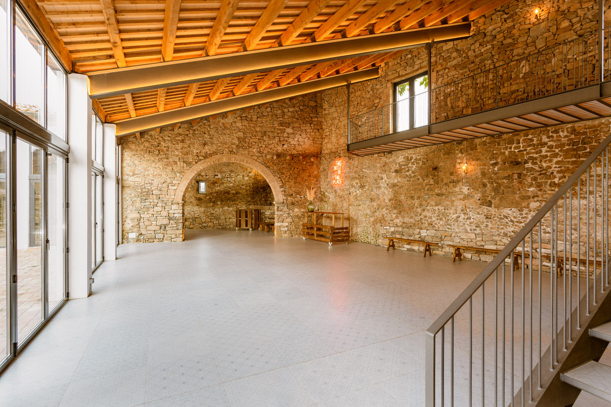 Inside the restored barn: stone walls, timber roof, and a mezzanine