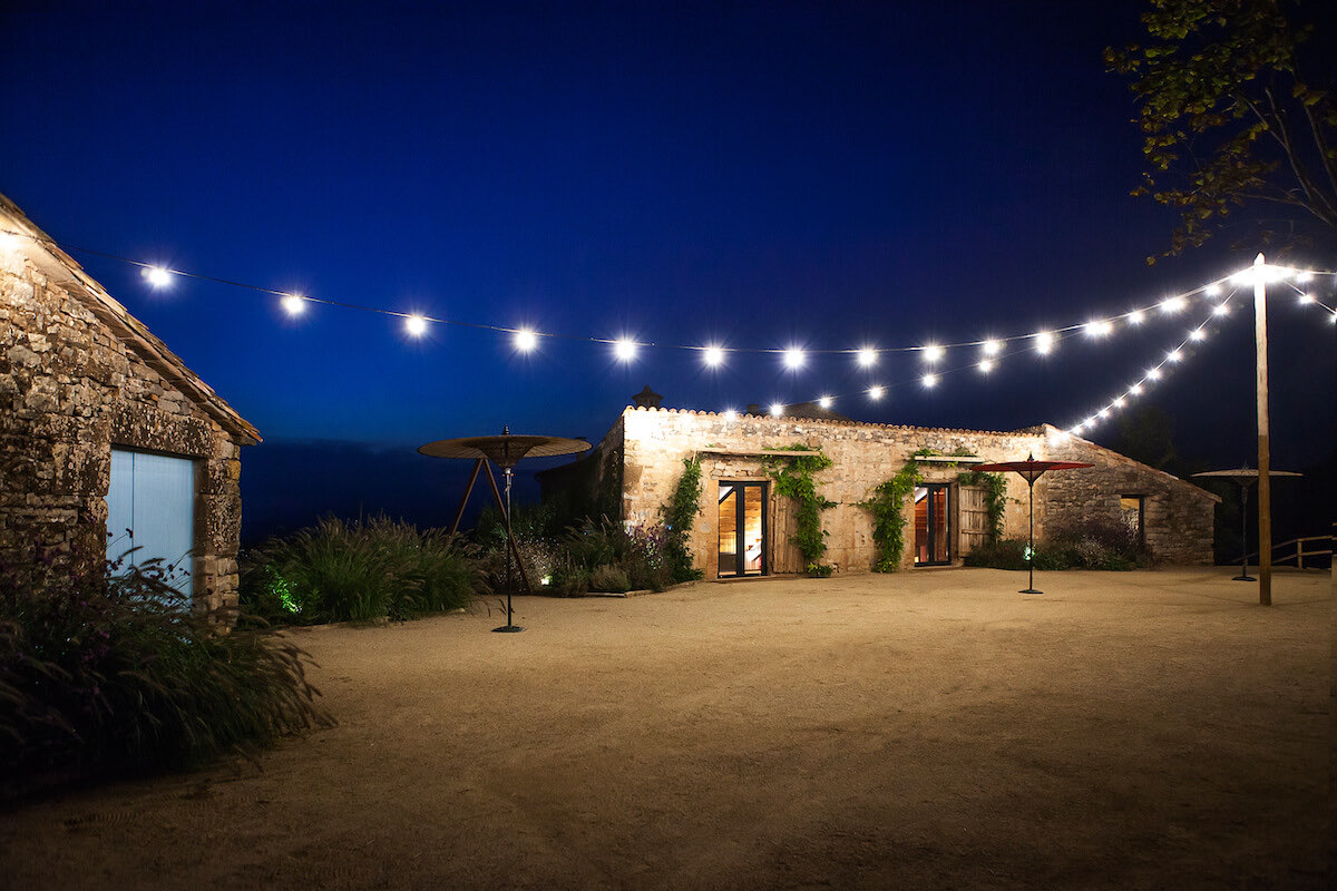 The farm at night under strings of festoon lights